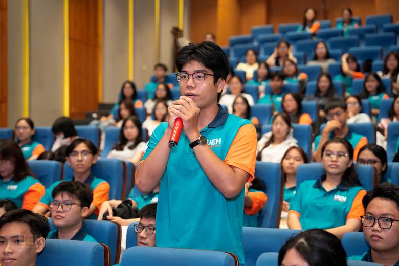 A person holding a microphone in front of a group of people

AI-generated content may be incorrect.