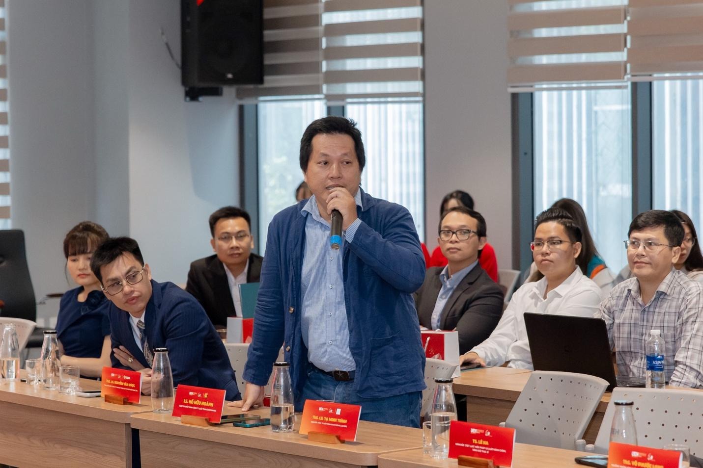 A person speaking into a microphone in front of a group of people
AI-generated content may be incorrect.